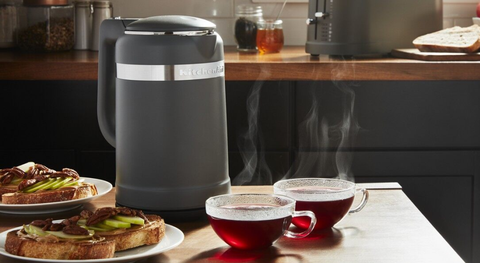 Electric tea kettle on a kitchen island next to cups of tea and toast. Electric tea kettle on a kitchen island next to cups of tea and toast.